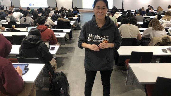 Lydia Chen stands in a large undergraduate lecture hall